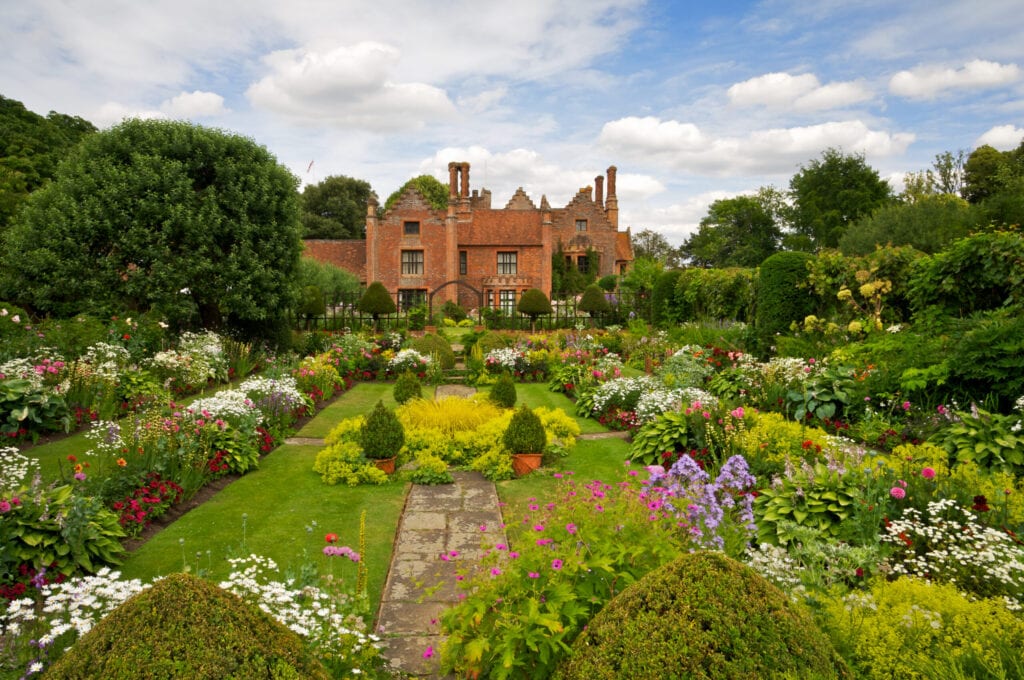 De prachtige bekroonde tuinen van Chenies Manor in Buckinghamshire met een grote verscheidenheid aan bloeiende planten en struiken.