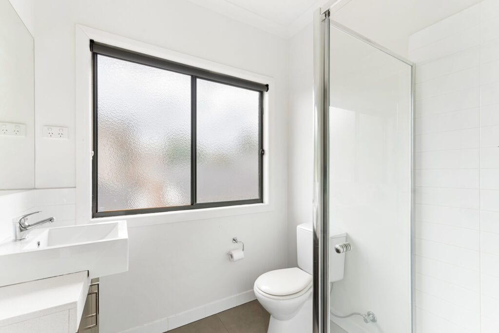 Getextureerde ramen zorgen voor licht en privacy in de badkamer.